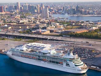 Image of Cruise Maryland Terminal next to I-95, with stately cruise ship in the foreground and Baltimore's Magnificent Inner Harbor in the background