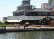 Scenic spring view of McCormick & Schmick's Seafood & Steaks Restaurant, 4 stories high with lots of windows, second floor deck and outside dining patio surrounded by colorful flowers & lush shrubbery located on Pier 5 with lovely waterfront views of Baltimore's famous Inner Harbor, MD