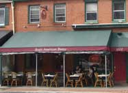 Image of Regi's American Bistro front sidewalk dining on the green and burgundy year-round heated outdoor patio on Light Street in historic Federal Hill Baltimore, MD