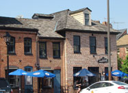 Image of waterfront dining outside the attractive historic brick building of the Point in Fells Restaurant on Belgian block Thames Street in Fell's Point, Baltimore, MD