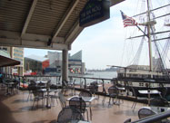 Awesome view of the harbor from the spacious second floor deck of Tir Na Nog Irish Bar & Grill showing the famous National Aquarium in Baltimore & the historic USS Constellation with its U.S. flag waving in the breeze at Harborplace, MD